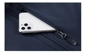 Detail of dark blue softshell vest showing a zippered chest pocket and a smartphone inside