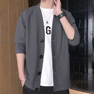 Detail view of dark grey corduroy jacket with large buttons and front patch pockets