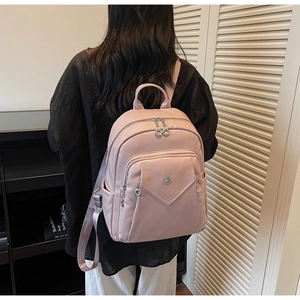 Detailed back view of a pink faux leather backpack with multiple zip compartments