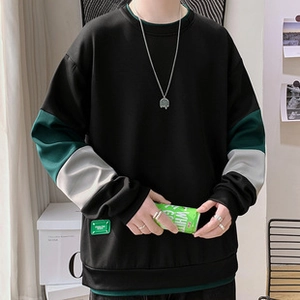 Detail of green square woven label on the hem of a color-block corduroy baseball jacket