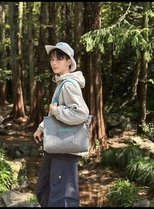 Detailed view of gray outdoor tote bag with mesh pocket and lightweight sun jacket