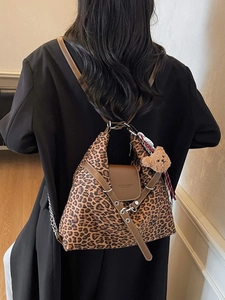 Leopard print large capacity tote bag with bear charm and leather strap on a model