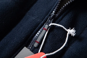 Detail of high-density navy fleece jacket with durable resin zipper and red reinforced stitching