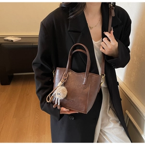 Dettaglio della borsa a secchiello vintage marrone scuro con ciondolo in peluche