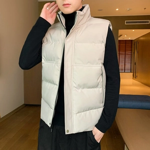 Close-up of quilted light beige men vest featuring a high collar and warm padding