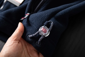 Detail of fleece jacket drawstring with transparent GN toggle and printed cord