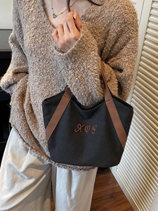 Minimalist black canvas tote bag with brown XQG embroidery and top handles for daily use