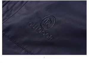 Detailed view of outdoor jacket embroidery logo and twill fabric texture on blue coat