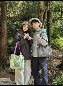 Outdoor lifestyle shot of contrast-color large tote bags with mesh pockets and embroidery