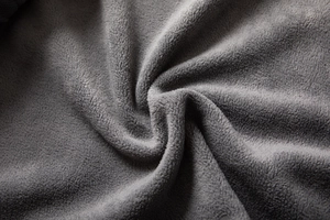 Macro shot of dark grey polar fleece fabric showing soft thermal texture and fibers