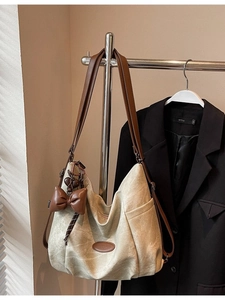 Vintage beige hobo backpack with brown bow and heart charm on a metal hanger