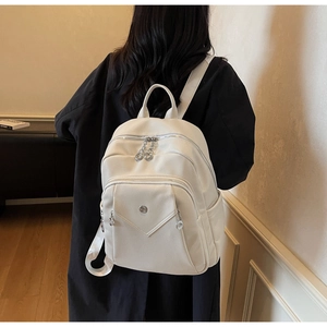 Close-up of white lychee pattern leather backpack with silver hardware and dual zippers