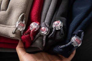 Close-up of adjustable drawstrings with brand logo on polar fleece outdoor jackets