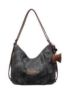 Dark grey canvas tote backpack with brown leather straps and side bow detail on white background