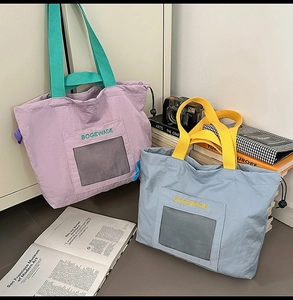 Detail of nylon tote bags with mesh pockets and contrast handles in a lifestyle setting
