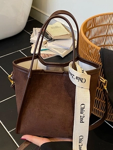 Sac seau en daim marron avec poignée en cuir et ruban siglé pour les déplacements quotidiens