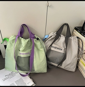 Detail of minimalist nylon tote bags featuring front mesh pockets and drawstring closure