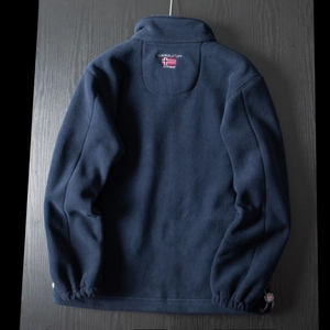 Detail of embroidered Norway flag logo on back of thick dark blue fleece outdoor jacket