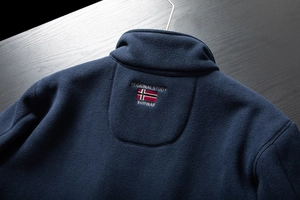 Detail of the embroidered Norway flag and RegionalStudy text on a navy fleece jacket
