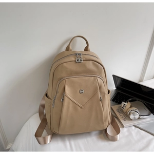 Litchi pattern faux leather backpack with silver zippers in a minimalist lifestyle setting