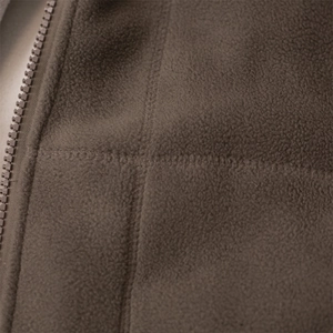 Macro shot of dark brown fleece texture with durable zipper and flatlock stitching detail