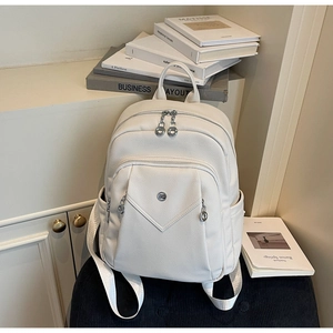 Close-up of white lychee texture leather backpack with silver logo and front pocket