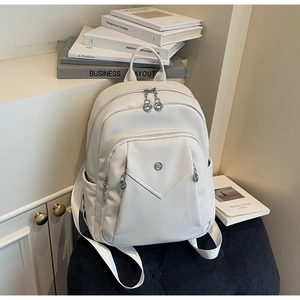 Detailed close-up of white lychee texture PU leather backpack with silver hardware finish