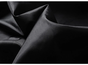 Close-up of black synthetic jacket fabric with high-gloss finish and soft silk-like texture