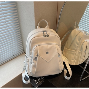 Close-up of beige lychee texture faux leather backpack with silver metal zippers