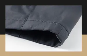 Detail of double-row stitching on the hem of a dark grey men's outdoor camping jacket