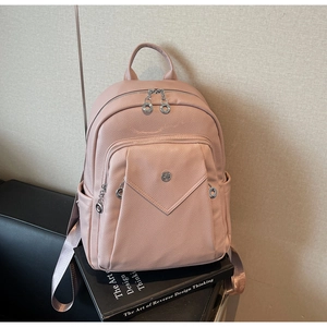 Detail view of pink leather backpack with litchi texture and silver metal zippers