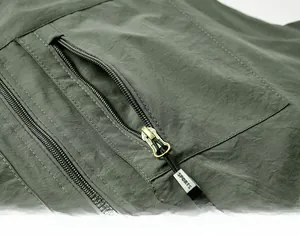 Détail du gilet extérieur vert armée montrant la poche zippée avec tirette SPORTS