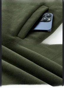 Détail de la doublure polaire et des poches multiples sur le gilet d'hiver vert
