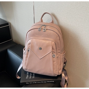 Detailed view of the dusty rose backpack with pebbled texture and silver zipper hardware