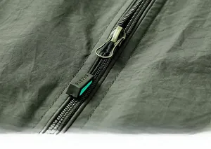 Détail de la fermeture éclair dorée et étiquette Sports sur gilet de plein air