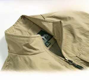 Vue détaillée d'une veste sans manches kaki avec col montant et zip métallique