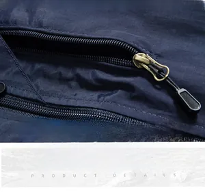 Dettaglio della tasca multifunzionale con cerniera in metallo sul gilet blu scuro