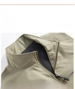 Gros plan du col montant d'un gilet kaki avec doublure en maille noire et fermeture éclair