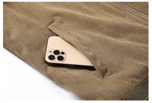 Detail of a brown corduroy jacket showing a deep side pocket with a mobile phone inside