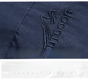 Dettaglio del gilet outdoor con logo ricamato professionale su tessuto blu scuro tecnico