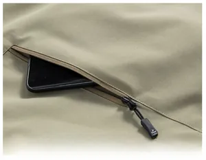 Gros plan d'une grande poche zippée sur un gilet d'extérieur kaki avec smartphone