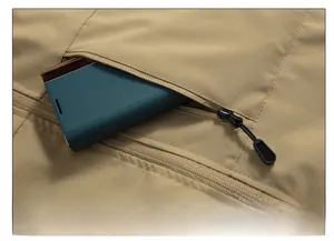 Close-up of khaki fishing vest showing durable chest zipper pocket and fabric texture
