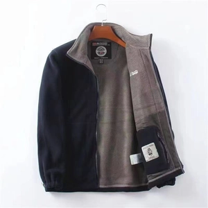 Detail of blue fleece jacket with grey lining and mountain logo embroidery on pocket