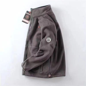 Detail of dark grey fleece jacket featuring outdoor patches and high-quality zipper