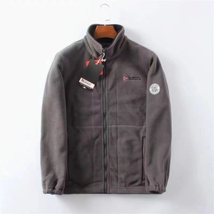 Close-up of grey fleece jacket featuring Norway embroidery and brand logo patches
