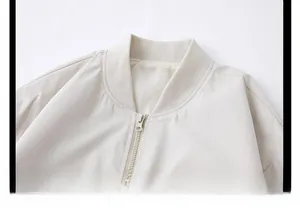 Close-up of baseball collar and metallic zipper on beige hooded windbreaker jacket
