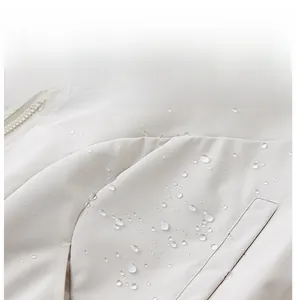 Detailed close-up of water-resistant fabric and zipper pocket on a beige windbreaker jacket