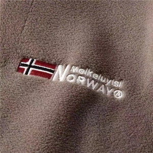 Detail of premium brown fleece jacket showing high-quality embroidery and Norway flag patch