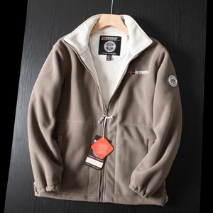 Detail of warm beige fleece outdoor jacket with stand collar and Norway embroidery