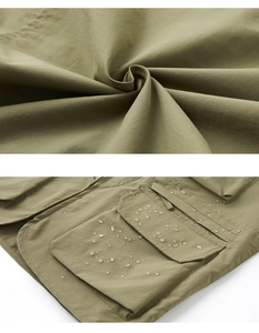 Detail of waterproof fabric with water droplets on multi-pocket outdoor vest